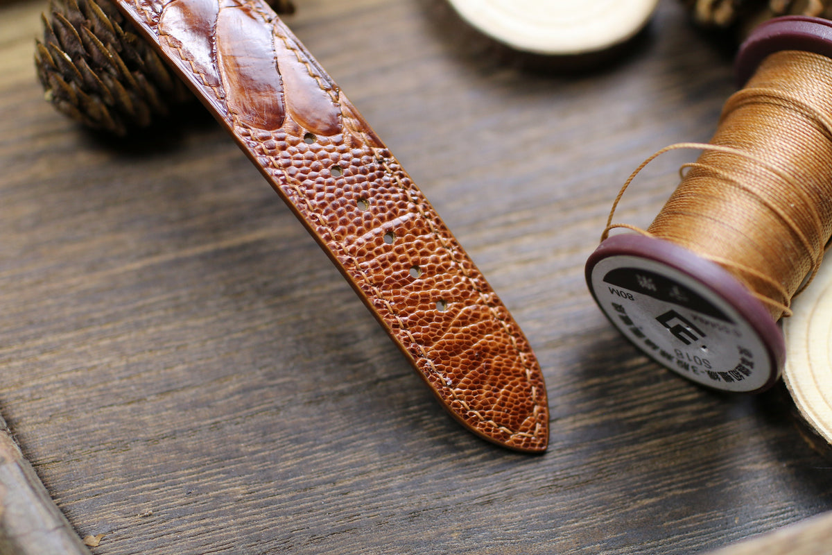 Ostrich leg strap tip with tan hand stitching